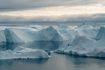 A stunning and surreal landscape unfolds in Greenland's UNESCO World Heritage Ilulissat Icefjord. Massive icebergs, freshly calved from the Sermeq Kujalleq glacier © Marek