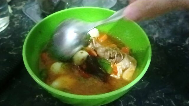 Homemade chicken soup with quail eggs, carrots, green beans, and mushrooms in a savory broth
