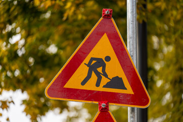 Traffic warning sign for roadworks on city street symbolizing infrastructure maintenance and caution for drivers during urban improvement projects