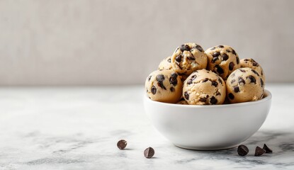 Close-up of a white bowl filled with freshly baked chocolate chip cookies on a light