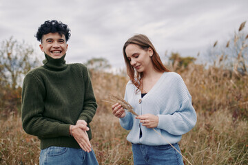 Authentic moment in a natural field captures two people sharing a candid exchange, showcasing real...