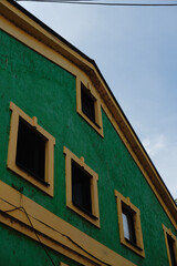Bright facade painted green and yellow with decorative texture on old building in Zemun