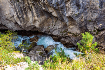 Beautiful stormy mountain river of emerald and blue hues runs over rocks top view. Wild and beautiful nature of Caucasian reserve, Russia