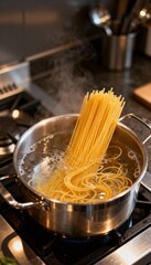 Spaghetti boiling in a stainless pot with steam and golden light.	