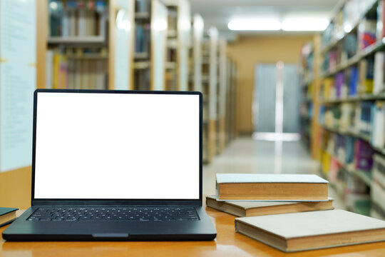 Blur library interior background for your design, desk with books and laptop