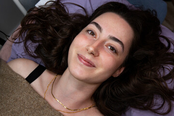 A cosmetic procedure at a beauty salon. A close-up of a woman's happy face with perfect eyebrows and eyelashes.