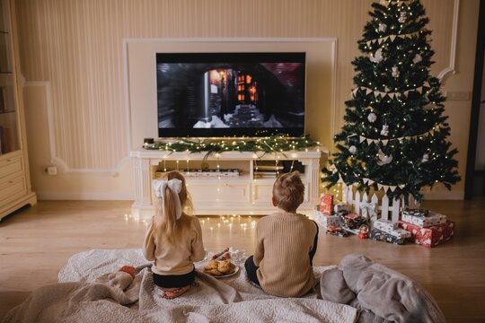 Children Watching Christmas Movie by Decorated Tree