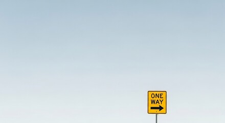 A yellow one way traffic sign with an arrow indicating a single direction, set against a wide open minimalist sky