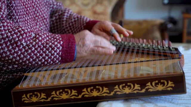 old man playing traditional turkish instrument qanun	