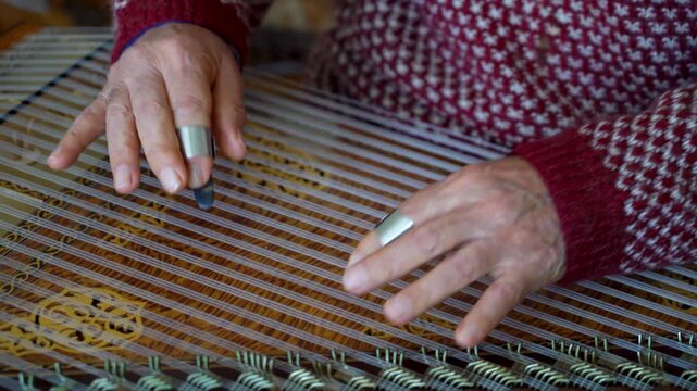 old man playing traditional turkish instrument qanun