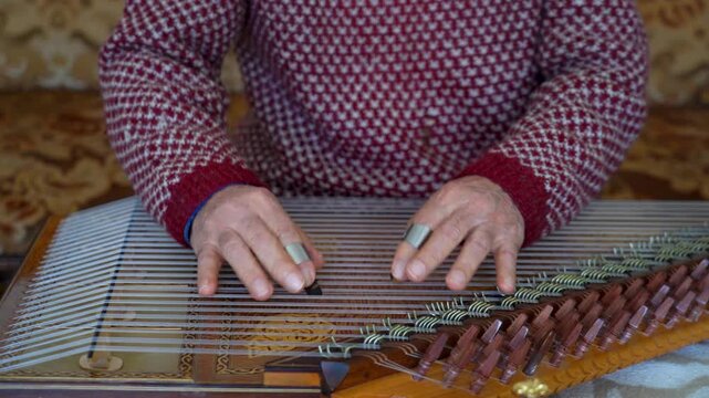 old man playing traditional turkish instrument qanun