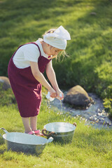 Charming girl washing clothes in the garden. Retro portrait