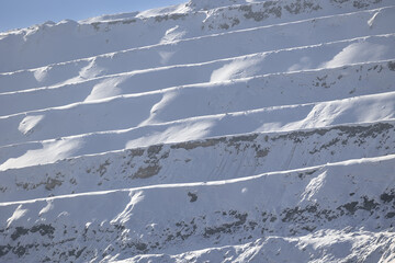 industry landscape Snow-covered terraces in open-pit mine during winter