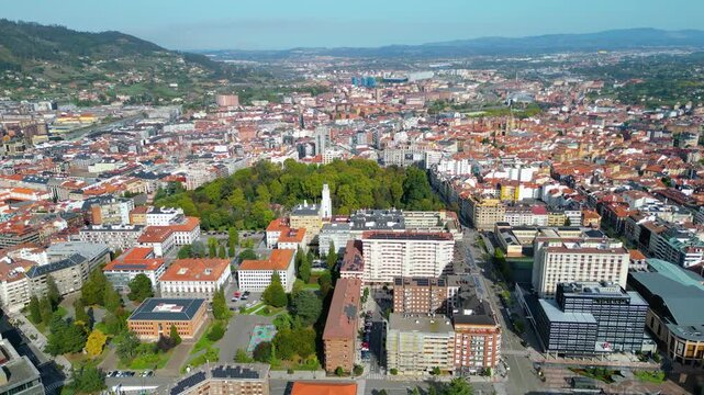 Aerial view of Oviedo, Spain, showcasing its historic architecture, bustling streets, and the iconic cathedral under clear autumn skies. A vibrant European city scene.