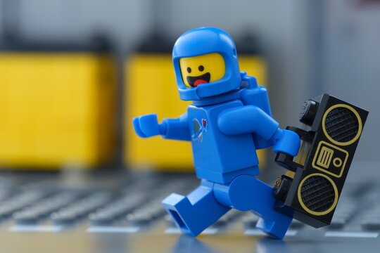 Tambov, Russian Federation - May 30, 2025 Blue Lego astronaut minifigure running with boombox. Close-up