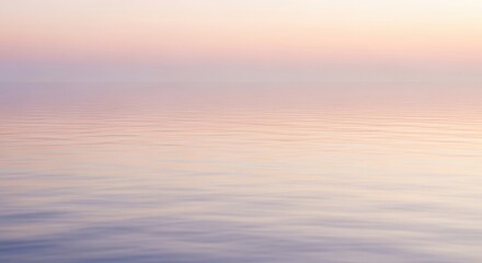 Serene view of a calm ocean surface under a pastel-colored twilight sky, creating a tranquil and peaceful atmosphere.