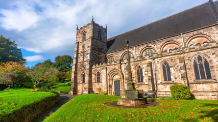 Historic stone church with tower and ancient cross
