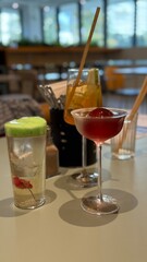 Colorful cocktails on table in cozy bar setting, featuring vibrant drinks and modern decor