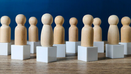 Wooden Peg People Figurines on White Cubes Representing Diversity, Leadership, and Group Discussion