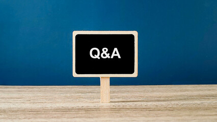 Q&A Sign on Miniature Blackboard on Wooden Table for Questions and Answers Concept