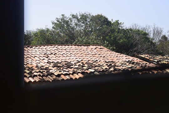 Telhado de casa com telhas sujas e novas, topo de casinha antiga no interior brasileiro
