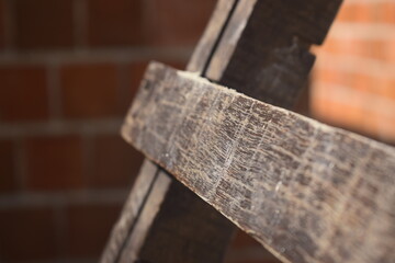 Detalhe de escada de madeira envernizada vista de perto em interior de canteiro de obras, alvenaria de tijolos vermelhos ao fundo 