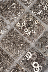 A top-down, organized view of assorted stainless steel metric spring washers in a multi-compartment...