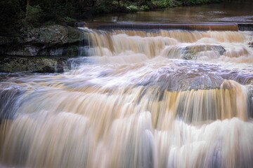Waterfall Cascading Over Rock Ledges in Australian Forest