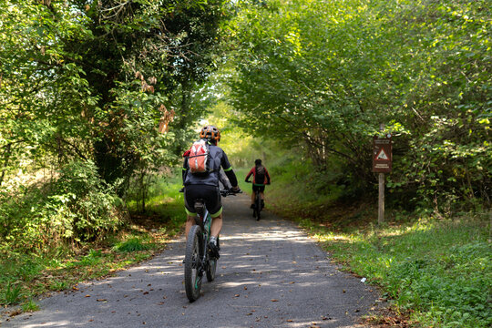 two cyclist riding on the path around Valdemurio reservoir in autumn. Bear Trail. Quir&oacute;s, Asturias, Spain