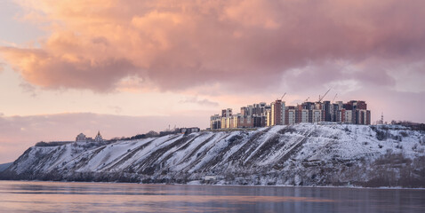 Panoramic view of new buildings in Krasnoyarsk. Orange sunset in winter on the banks of the...