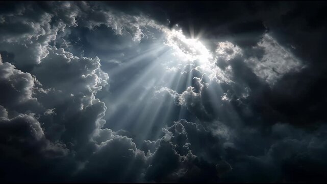 Bright sunlight breaks through dark stormy clouds creating divine rays in the heaven to be used for inspirational background design.