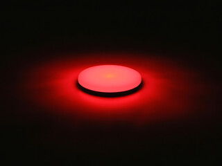 Single red led light emitting a soft glow in complete darkness