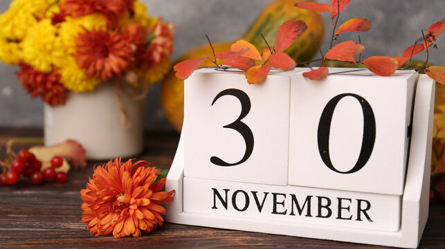 Cozy Autumn November Calendar Display with Chrysanthemum Flowers and Fall Leaf Decor on a Wooden Table