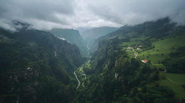 A breathtaking aerial view of lush green mountains covered with dense forests and mist, with steep rocky cliffs descending into a wide valley below. The scene is filled with rolling clouds and soft 