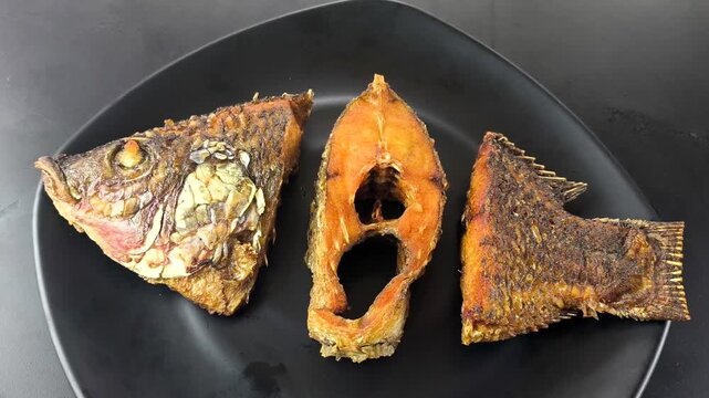 Deep-fried tilapia fish in plate, indoor Chiangmai Thailand.