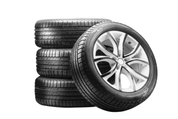 Four summer tires mounted on alloy wheels are neatly stacked, showcasing their design and tread. This setup highlights seasonal tire service and sales opportunities.