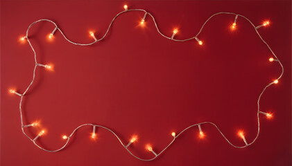 A string of warm, glowing LED fairy lights is arranged in an elongated, wavy frame shape against a vibrant, deep red background, leaving a clear space in the center for text or design.