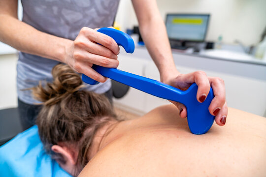 Physiotherapist performing instrument assisted soft tissue mobilization