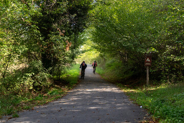 two cyclist riding on the path around Valdemurio reservoir in autumn. Bear Trail. Quir&oacute;s, Asturias, Spain