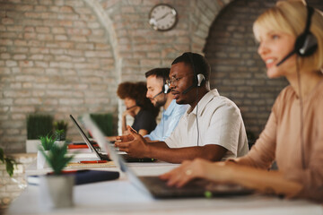 Support Team Working in Modern Office With Headsets and Laptops for Customer Service