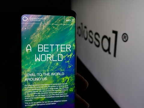 Stuttgart, Germany - 10-20-2025: Person holding cellphone with webpage of de-extinction company Colossal Biosciences on screen in front of logo. Focus on center of phone display.