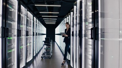 professional woman monitors servers and manages data center efficiently, female it administrator skillfully inspects server racks amidst cooling vents and security - Powered by Adobe