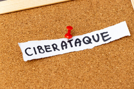Handwritten word CIBERATAQUE pinned on a corkboard. This visual symbolizes cybersecurity threats and digital attacks, relevant in technology discussions and educational contexts.