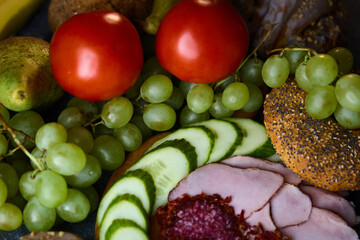 Culinary composition of ham salami tomatoes grapes and cinnamon buns