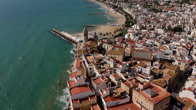 Drone top view of old town and beach breakwaters, Sitges, Spain.