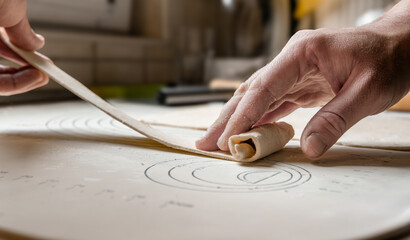 Obraz premium A baker rolls out a dough