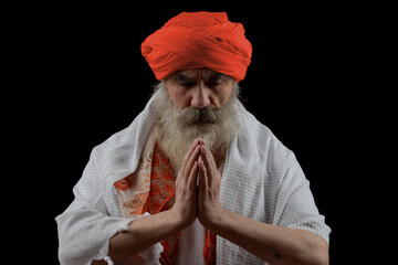 Senior man in a turban is associated with a Hindu, Jain, Buddhist. Prayer gesture.