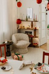 Festive interior view with red ornaments, armchair, soft lights, and a cozy reading nook, modern Christmas decor.