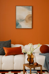 Elegant living space with bold orange wall, designer lighting, and sculptural vases. Mock up poster above sofa.