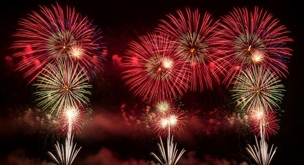 Gorgeous red and white fireworks exploding brilliantly in a dark night sky creating an amazing colorful display to celebrate a happy New Years Eve or merry Christmas holiday event 2026